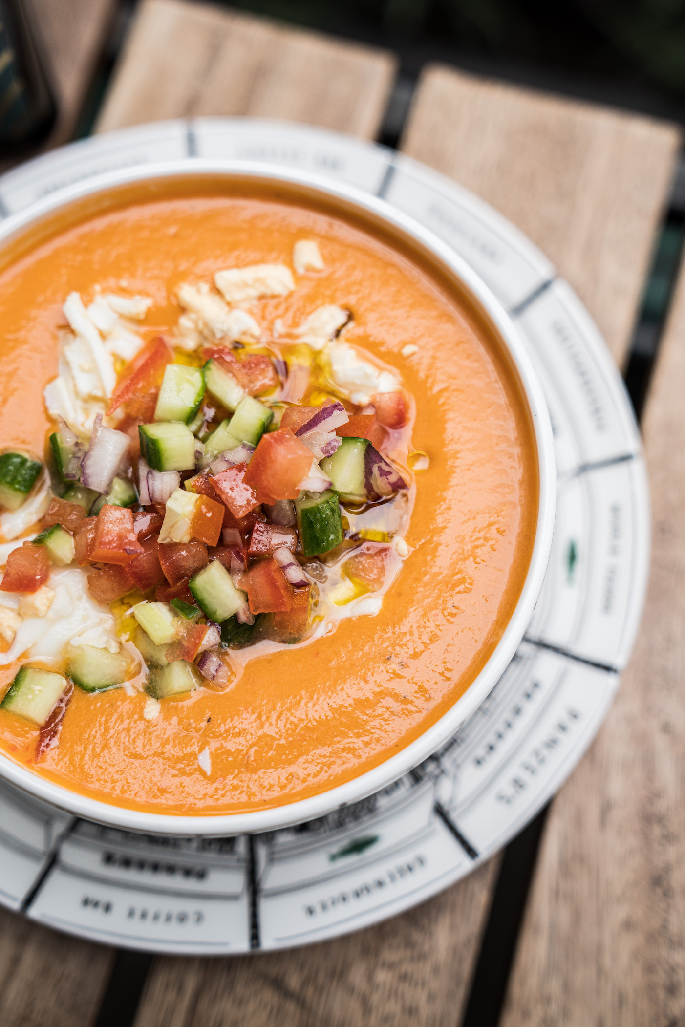 A bowl of homemade Panzer's gazpacho soup, loaded with fresh toppings