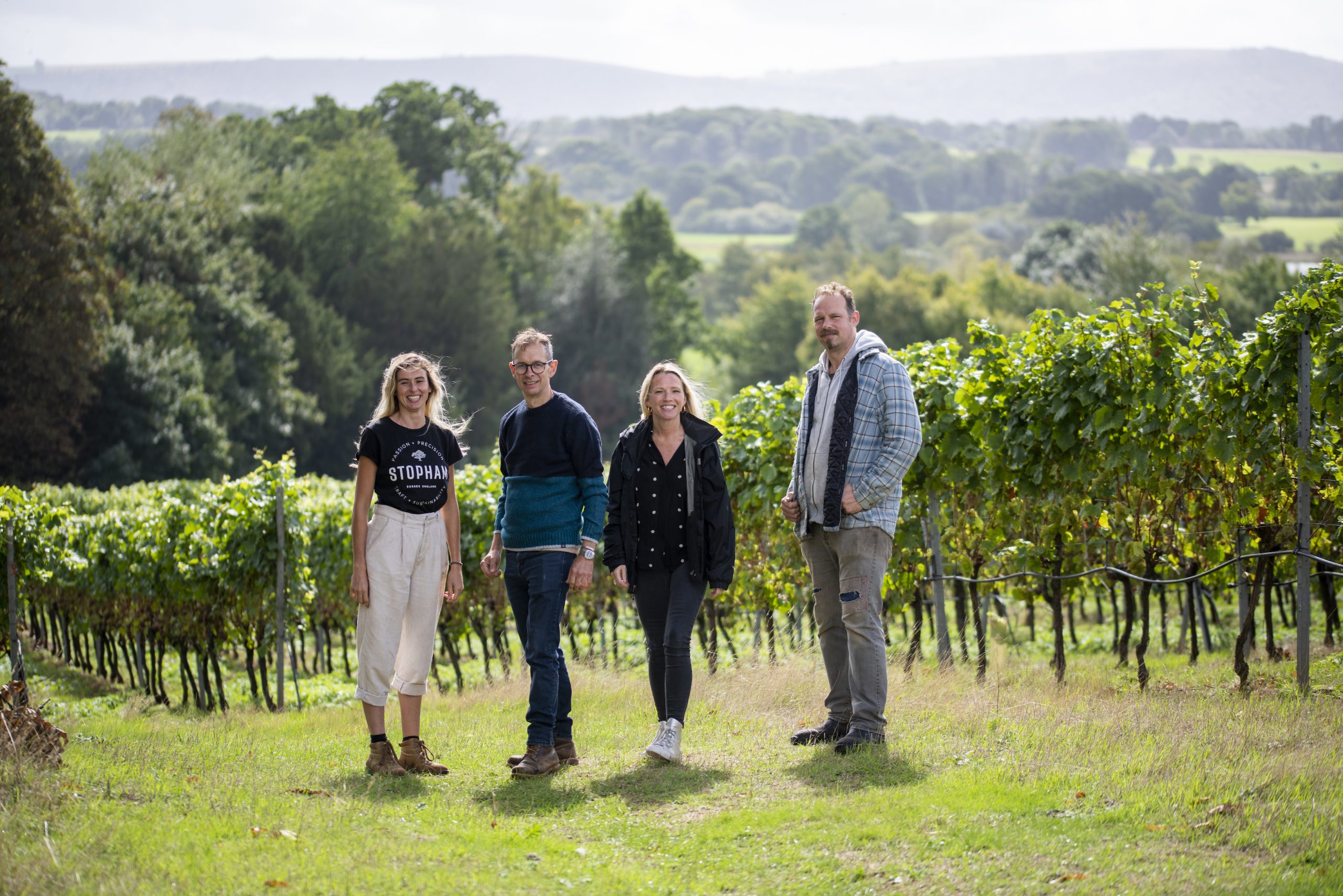 The team from the Stopham Vineyards stands in front of their vines in Sussex, England.