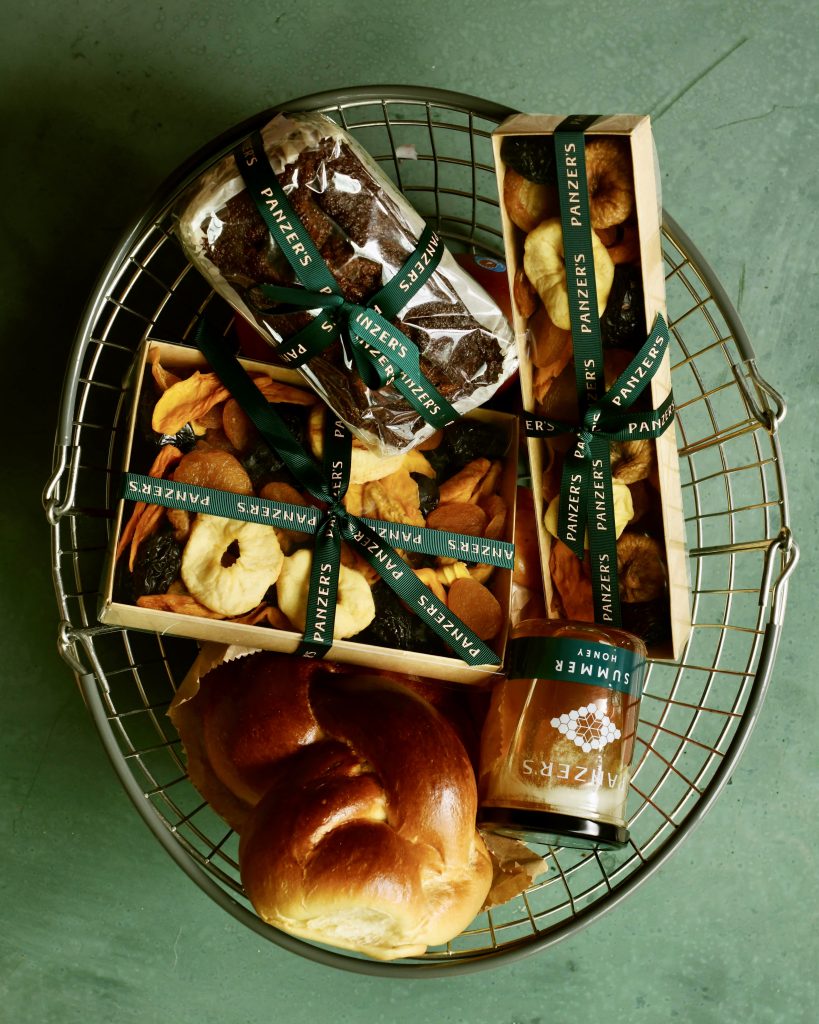 Basket of Panzer's Rosh Hashanah goodies, from their 4 generation recipe honey cake, dried fruit, challahs and honey