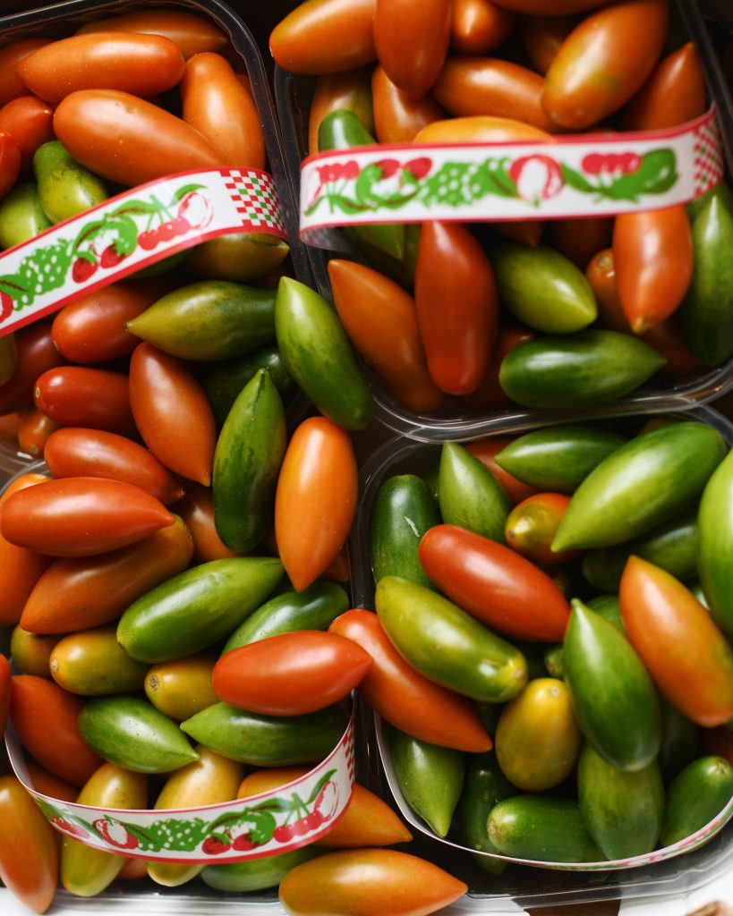 Punnets of red and green torpedino tomatoes