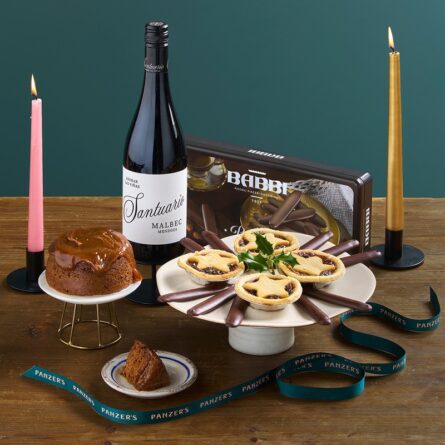 Festive Fayre Christmas hamper displayed in a cosy seasonal setting, filled with gourmet festive foods, sweet treats, and drinks for sharing.